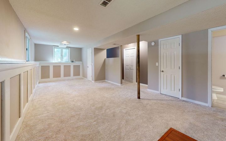 Finished basement with painted drywall, carpet and recessed lights