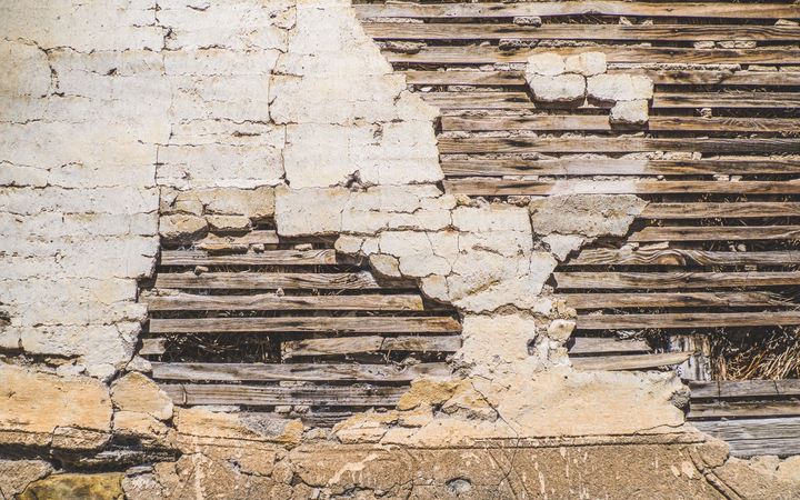 Crumbling plaster wall with the wood lath showing through